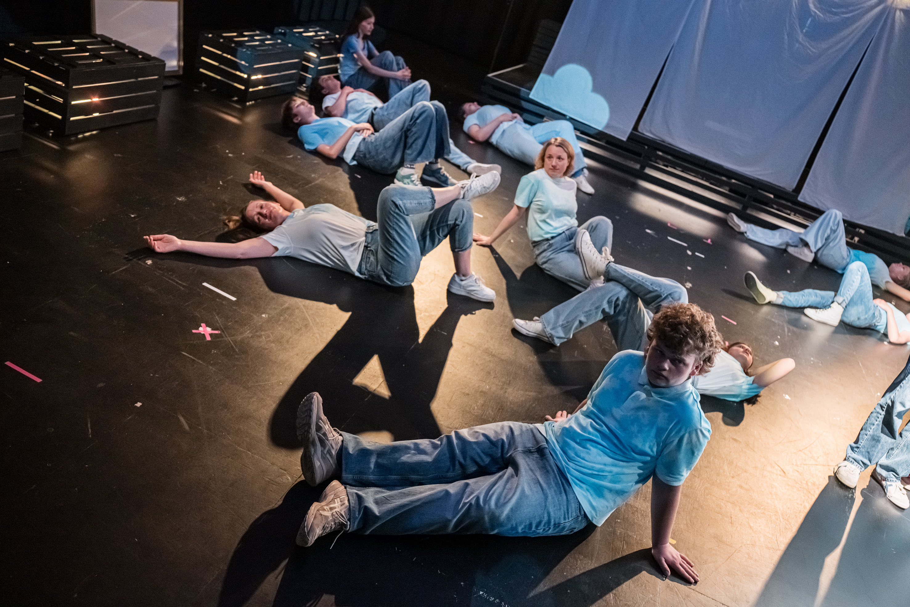 Gruppe von jungen Menschen auf der Bühne verteilt.