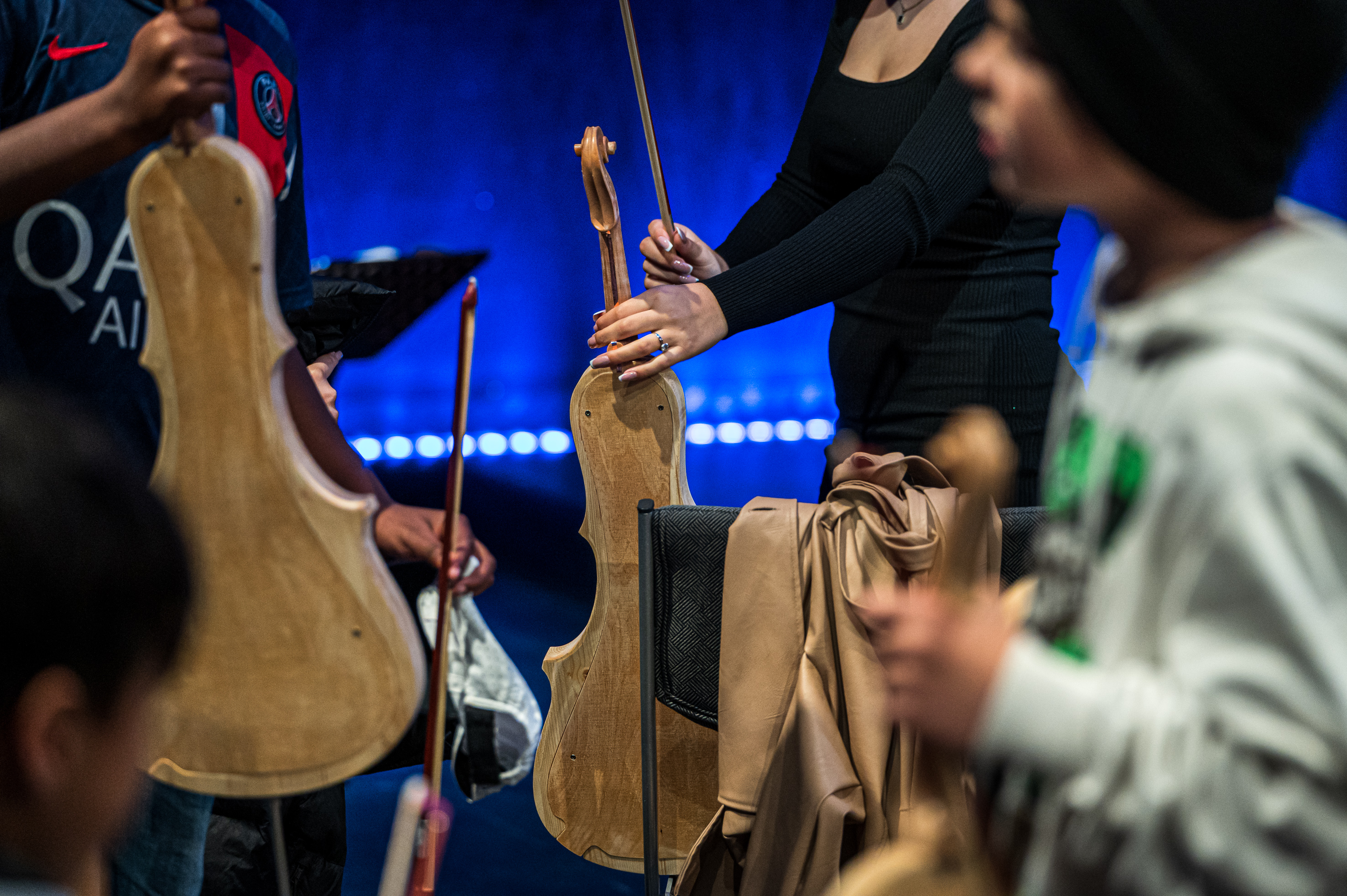 4 Personen aus dem Publikum halten Streichinstrumente.