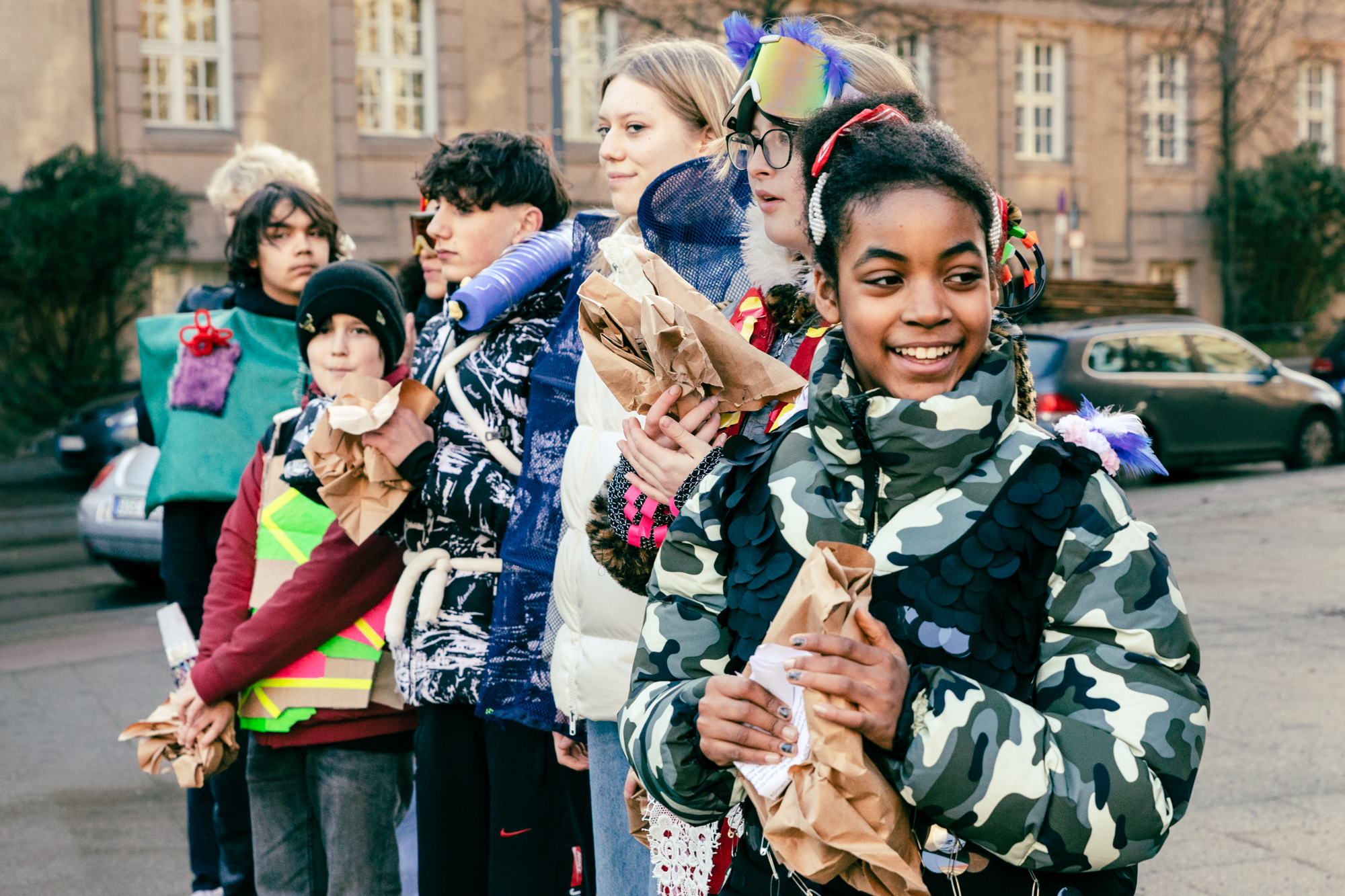 7 Personen auf der Straße unterwegs, zum Teil mit Kostümen.