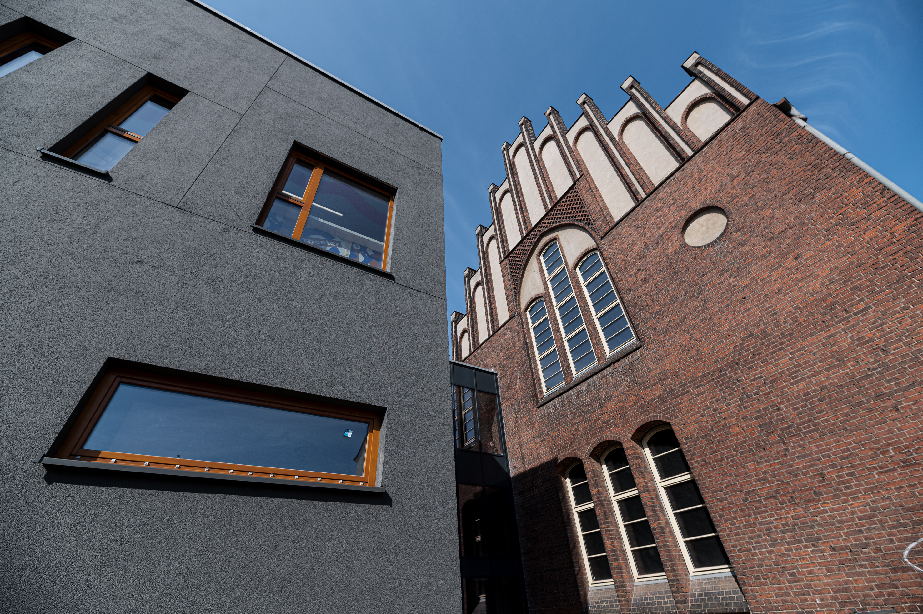 Theatergebäude von außen. Altes Backsteingebäude neben modernem Anbau. Nahaufnahme.